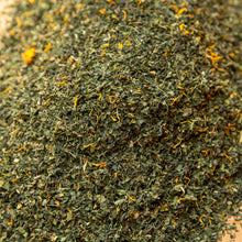 Load image into Gallery viewer, Dry green tea leaves on a wooden surface
