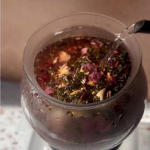 Load image into Gallery viewer, Hot water being poured into a glass teapot filled with loose leaf tea.
